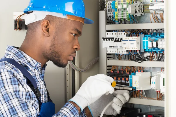 depositphotos_118476202-stock-photo-technician-repairing-fusebox-with-screwdriver